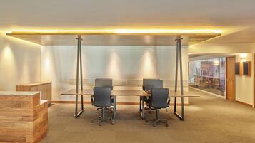 A modern office space with two desks, chairs, and a reception area.