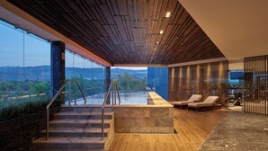 A modern interior with a pool, wooden flooring, and a view of the outdoors. - Fiesta Americana San Luis Potosi (San Luis Potosi)