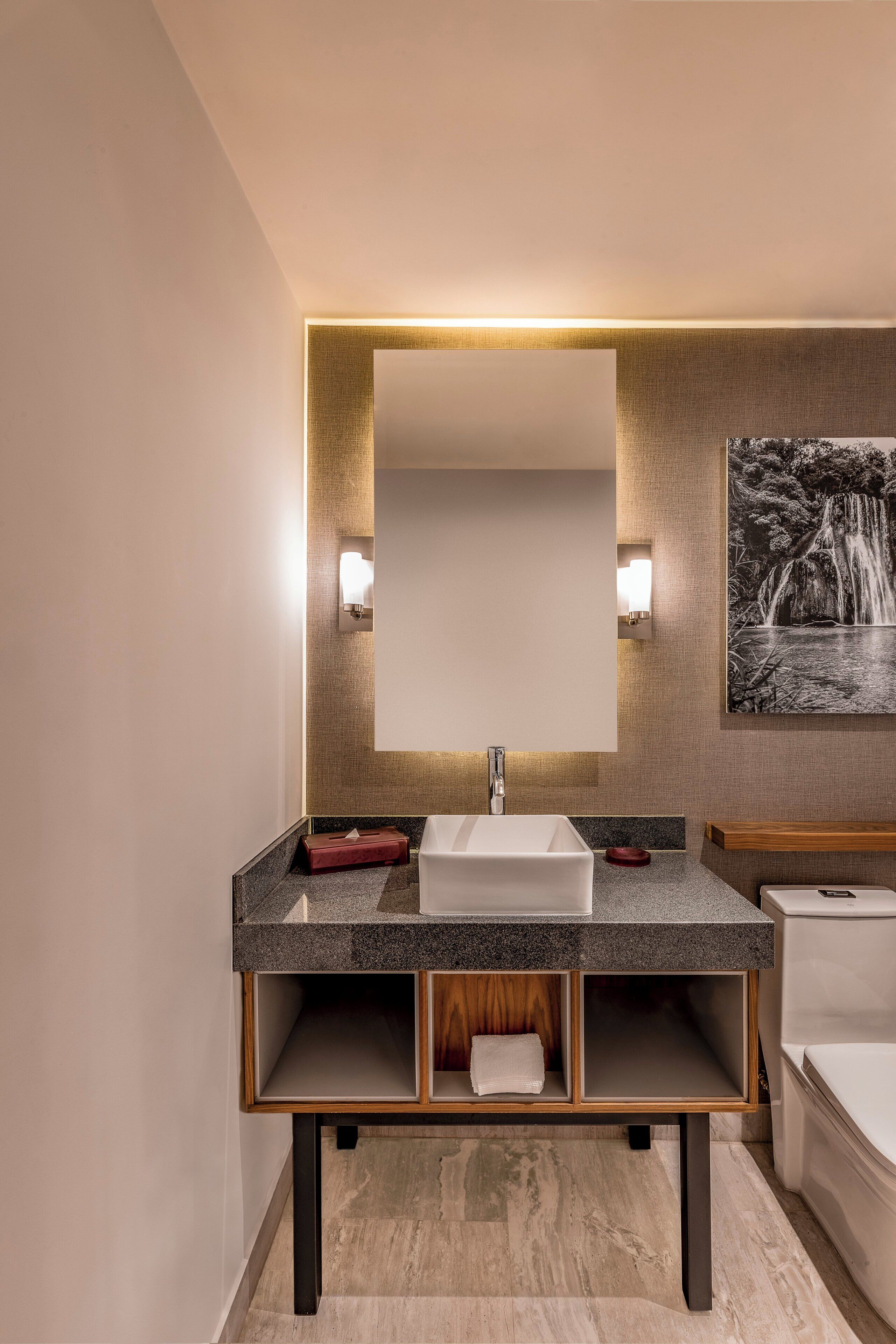 Une salle de bain moderne avec un grand miroir, un lavabo et des toilettes.