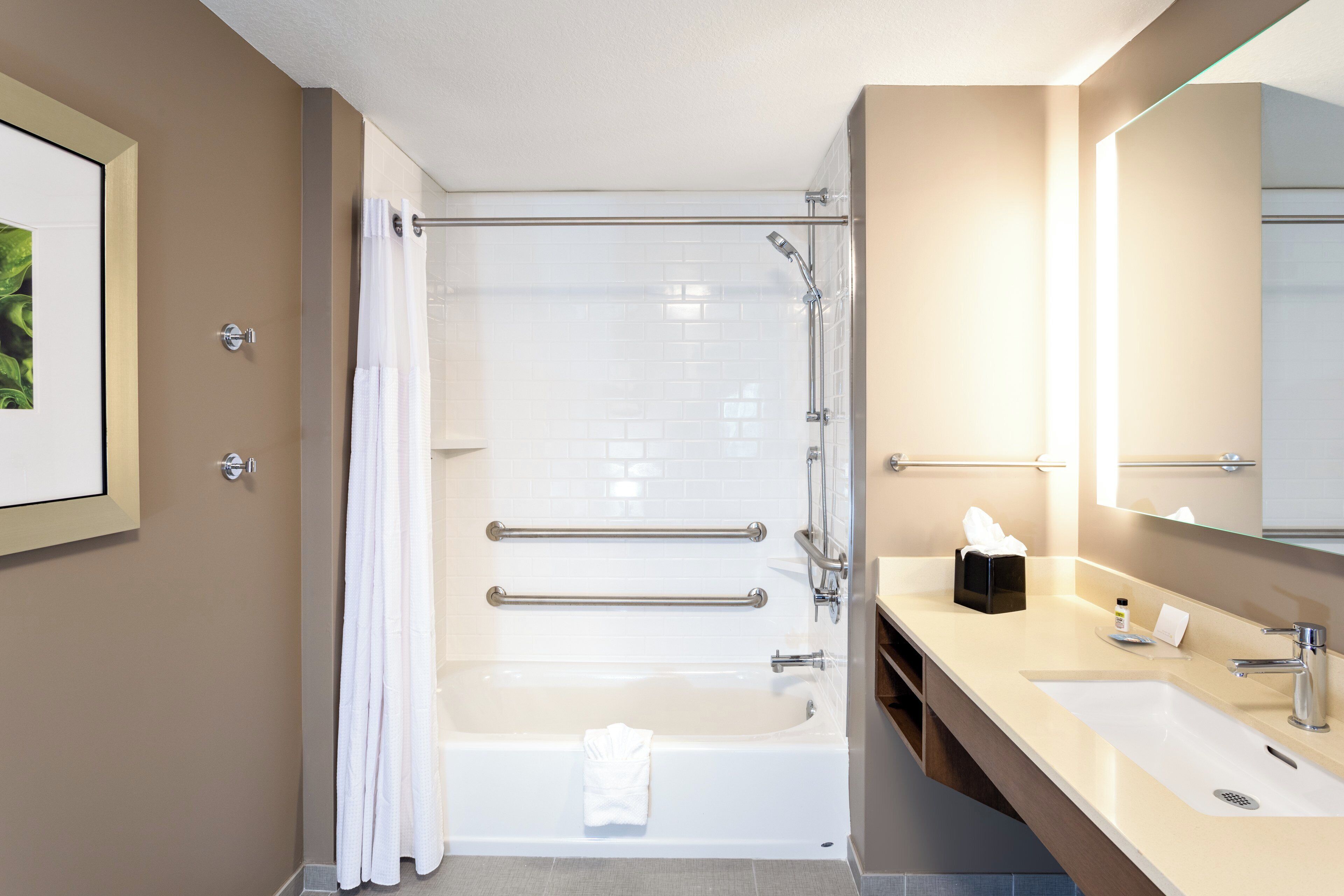 Ein modernes Badezimmer mit einer Duschkabine, einer Badewanne und einem Waschtisch mit Spiegel.