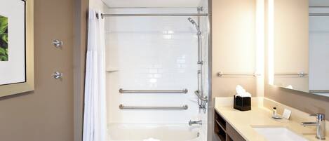 Un baño moderno con ducha envuelta en vidrio, una bañera y un tocador con espejo.