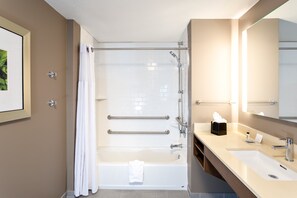 Un baño moderno con bañera, lavamanos y espejo.