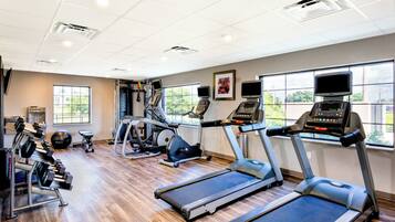 A gym with treadmills, elliptical machines, and free weights.