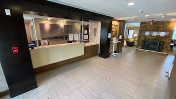 A reception area with a counter, a stone fireplace, and a tiled floor.
