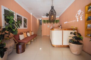A reception area with a reception desk, a sofa, and potted plants.