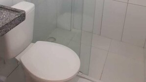 A small bathroom with a toilet, a shower stall, and a sink. - Pousada Aliança (Ipojuca)