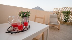 A table with a pitcher and glasses of red drink, a chair, and a view of a mountain. - Dove sorge il sole (Custonaci)