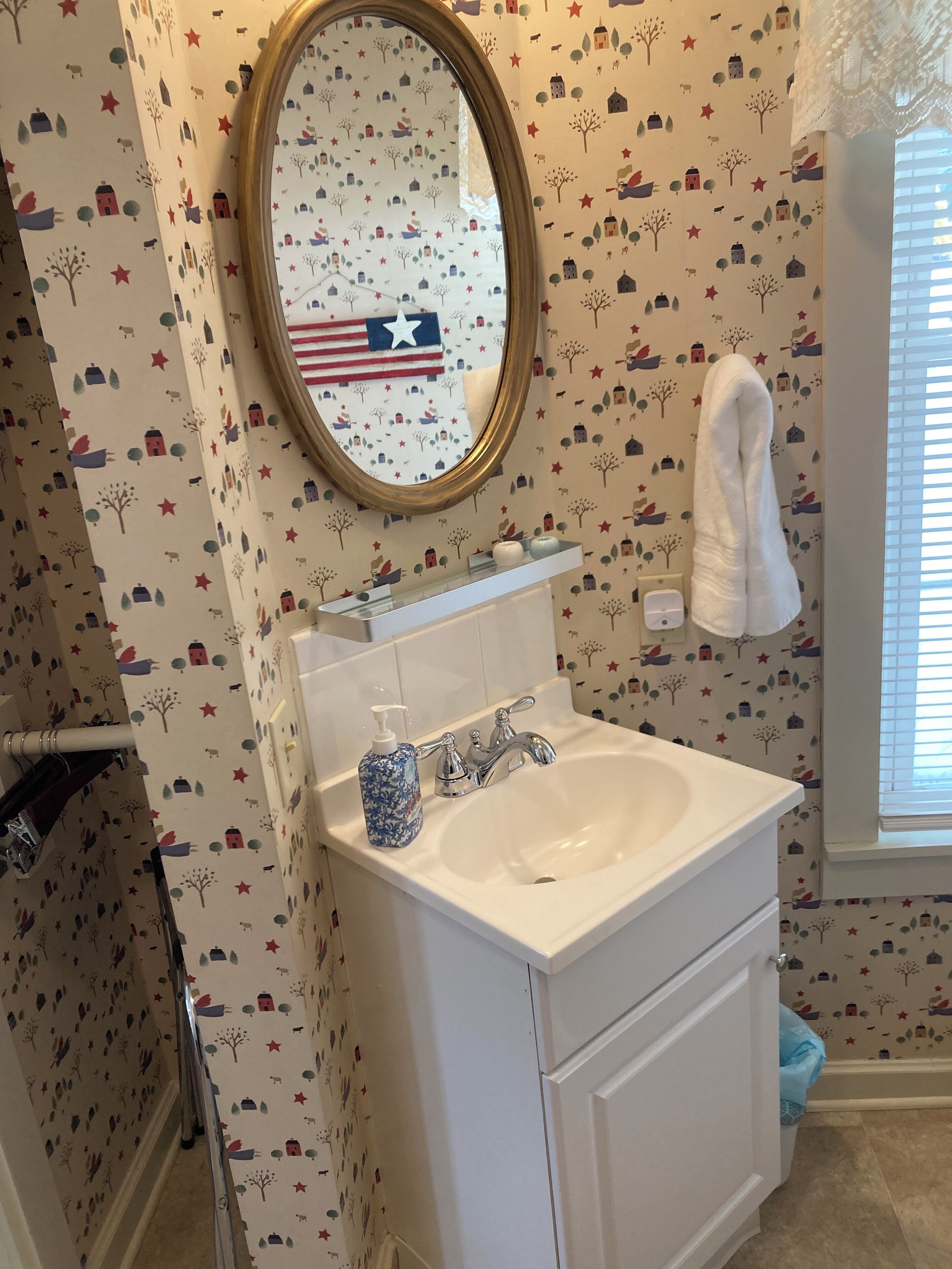 A bathroom with a white sink, a mirror, and a towel rack.