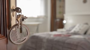 A room with a bed, a desk, and a door with a key. - La Casa delle Stagioni (L'Aquila)