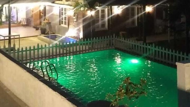 A multi-story hotel with a swimming pool surrounded by a white fence. - Kimberly By Jade (Kunigal)