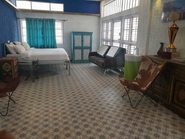 Une pièce comprenant un lit, deux chaises, une armoire et un trophée posé sur une commode.