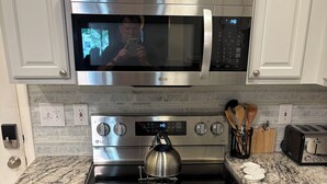 Une cuisine équip ée d’un four à micro-ondes, d’une cuisinière, d’un four et de plans de travail en granit.