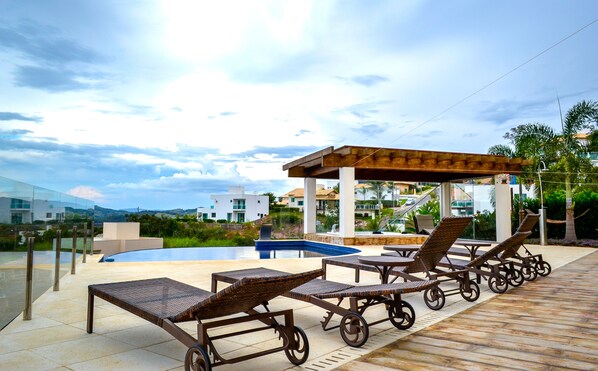 Outdoor pool, an infinity pool, pool umbrellas, pool loungers
