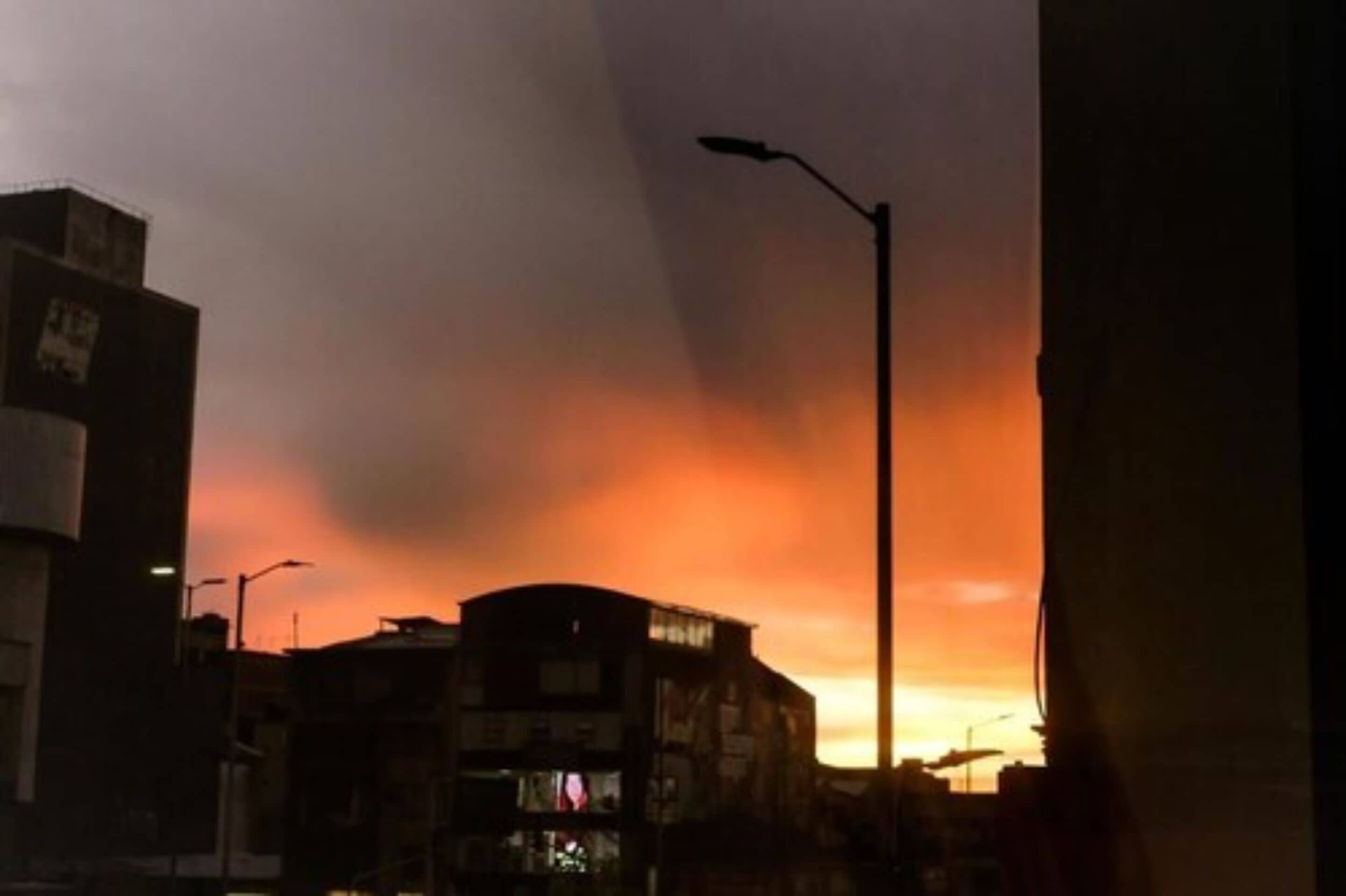 A cityscape with buildings silhouetted against a sunset sky.