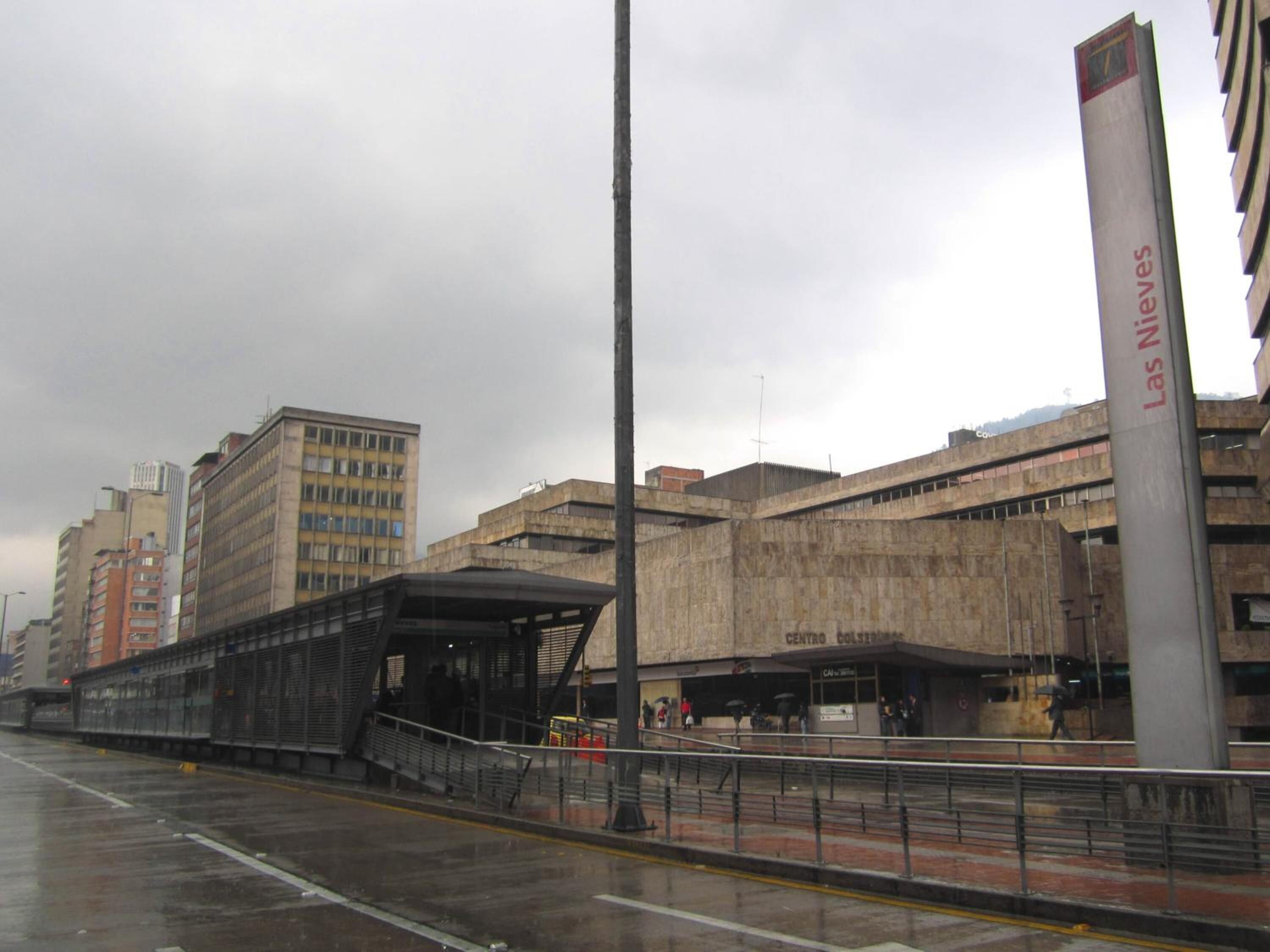 A train station with a covered waiting area and a tall vertical sign.