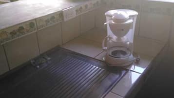 A kitchen with a coffee maker on the counter.