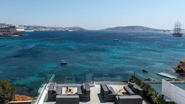 A luxurious outdoor seating area with a clear view of the sea and boats. - Obsession Mykonos (Mykonos)