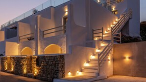 A modern building with a glass balcony, a staircase, and stone walls. - Obsession Mykonos (Mykonos)