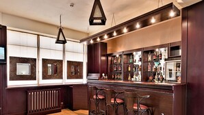 Un amplio salón con piso de madera, una mesa de centro de vidrio y un banco de metal con cojines.