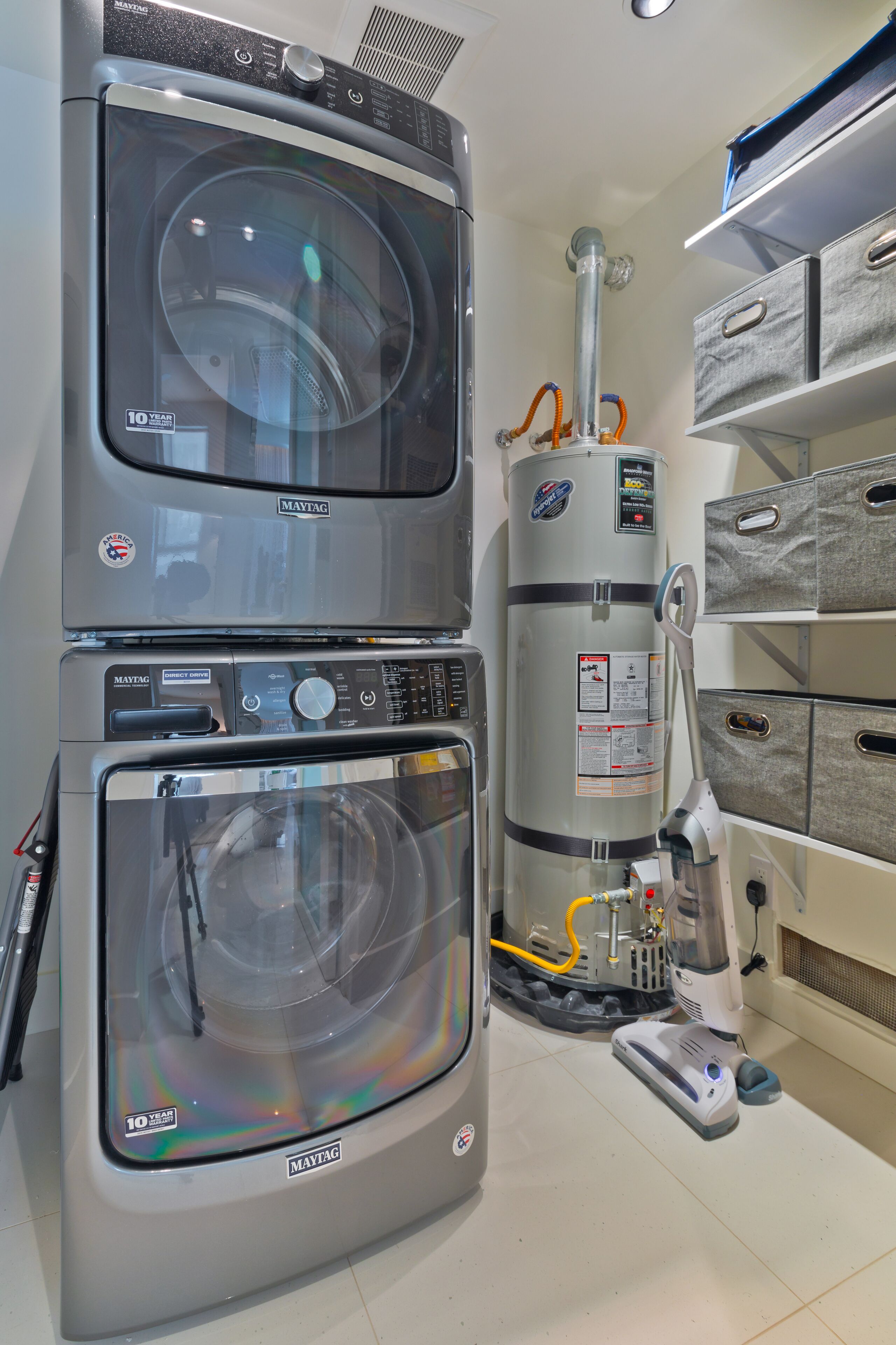 Een wasserette met twee Maytag wasmachines, een boiler en een stofzuiger.