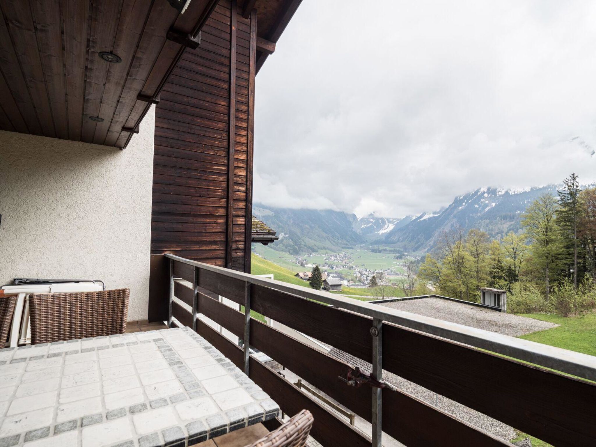 A balcony with a view of a valley and mountains.