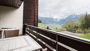 Un balcon avec vue sur une vallée et des montagnes.