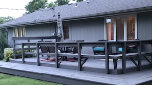 Una terraza cubierta con mobiliario exterior, una mesa de patio y sillas.