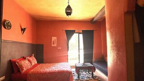 Un dormitorio con cama, un banco y una ventana.