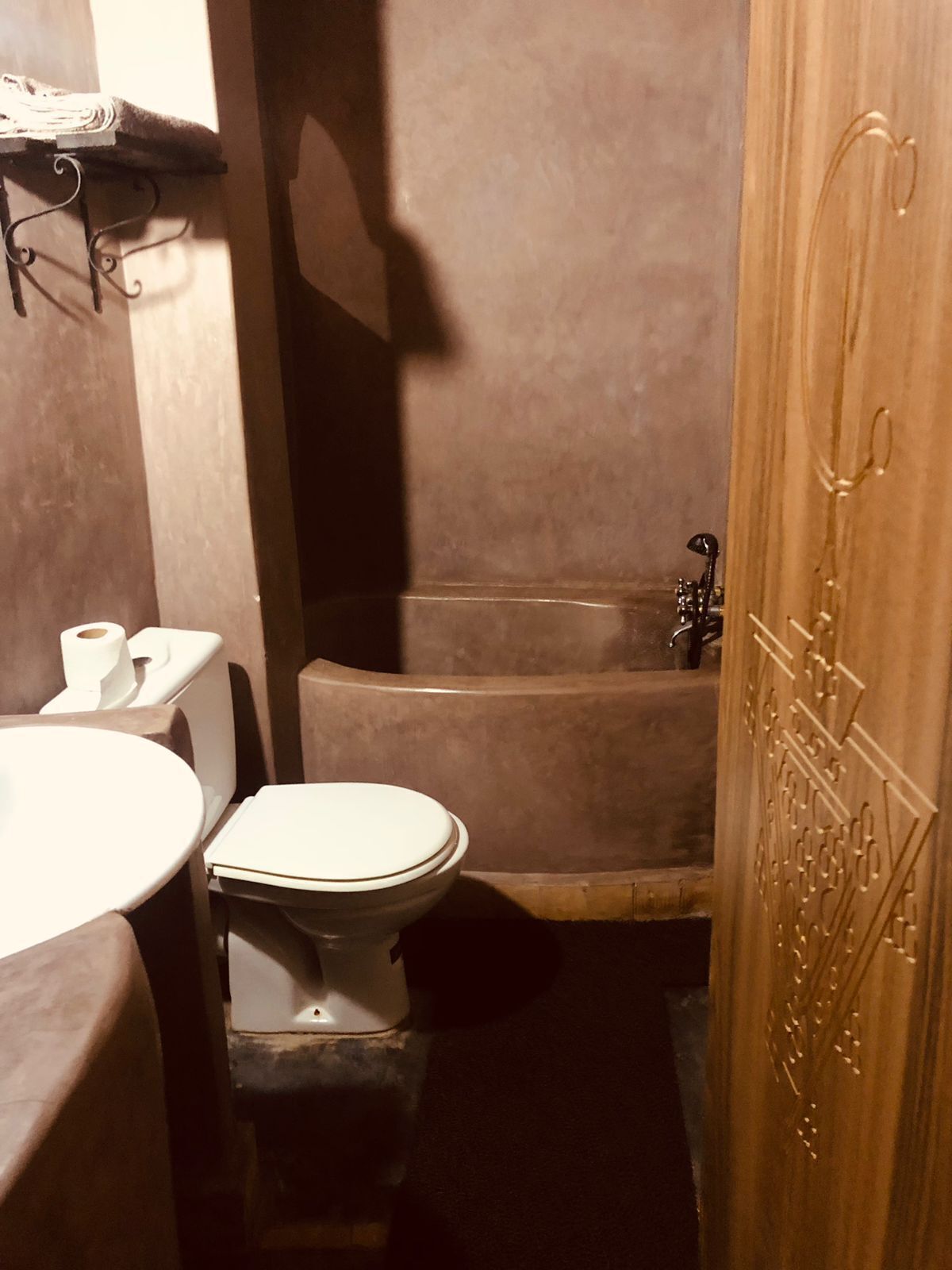 Un baño pequeño con inodoro, lavamanos y zona de ducha.