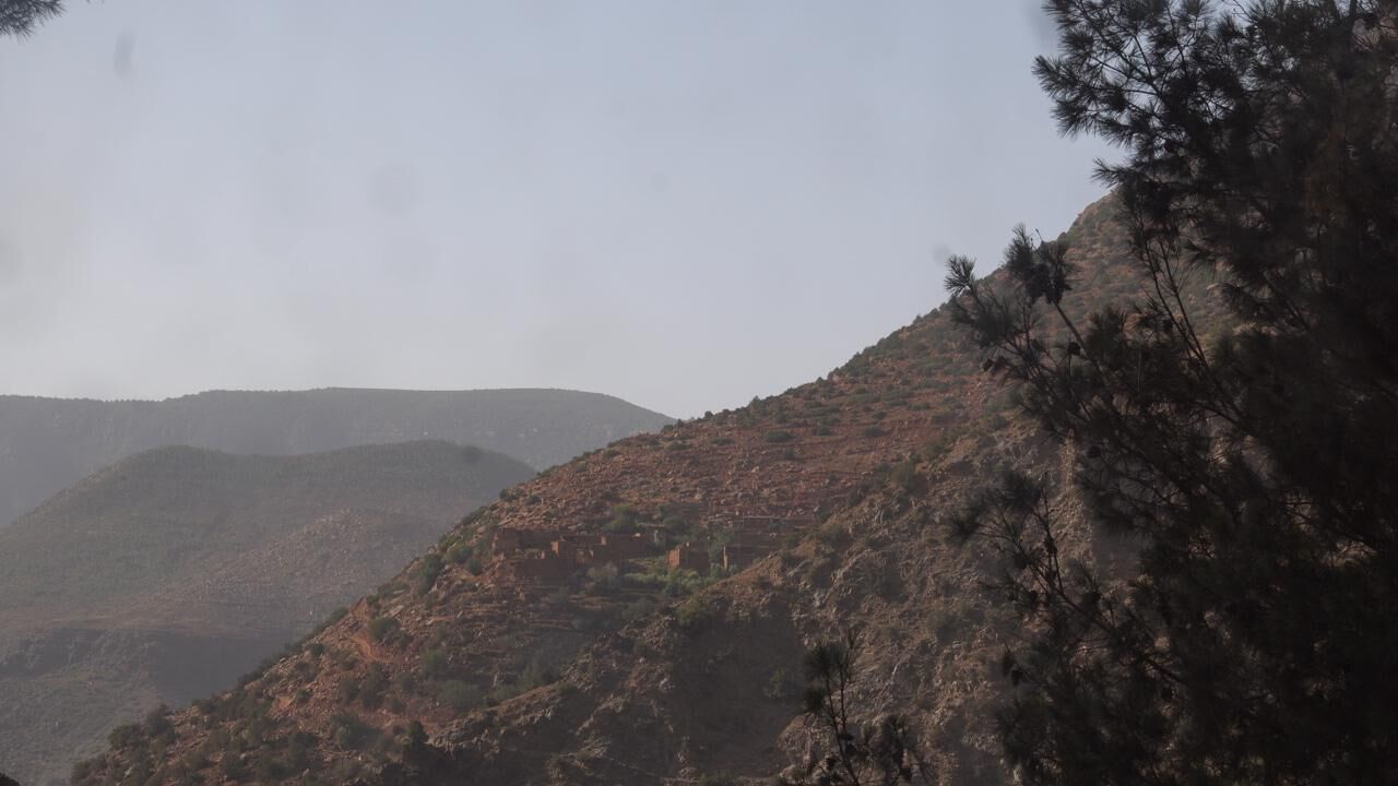 Un paisaje montañoso con terreno rocoso y vegetación escasa.