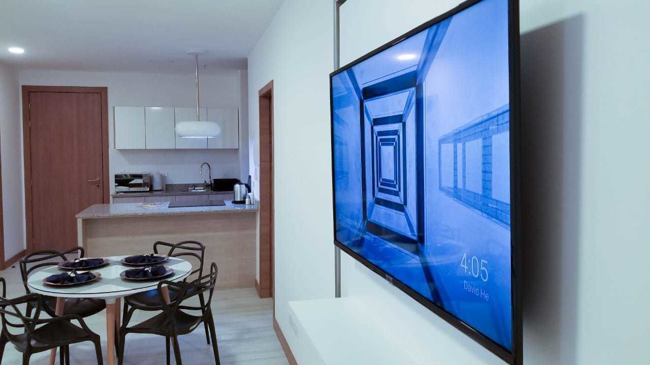A modern kitchen with white cabinets and a dining area with a glass table and chairs.