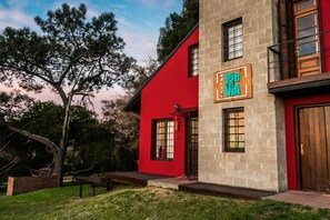 A red building with a sign reading "Pie de Via Hostel". - Pie De Via Hostel (Sierra de los Padres)