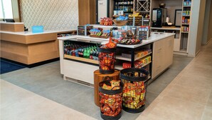 A hotel lobby with a reception desk, a coffee station, and snack dispensers. - Hilton Garden Inn Cedar Park Austin (Austin)