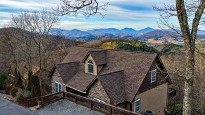 A house with a stone facade, a brown roof, and a view of mountains. - Blue Ridge View Cabin: Hot Tub, Pool Table, Pet-Friendly, Near Blowing Rock & Parkway (Boone)
