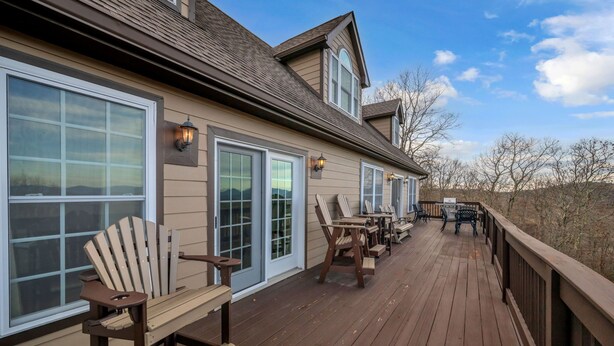 A wooden deck with outdoor seating, large windows, and a view of the surrounding landscape. - Blue Ridge View Cabin: Hot Tub, Pool Table, Pet-Friendly, Near Blowing Rock & Parkway (Boone)