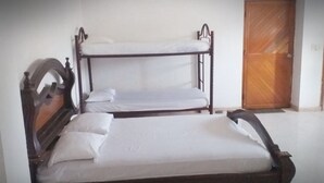 Ein Etagenbett mit zwei Schlafstellen, eine Holztür und eine weiße Wand.