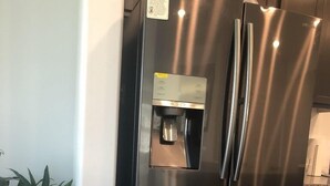Ruostumattomasta teräksestä valmistettu jääkaappi, jossa on vesiautomaatti ja pakastinosa.