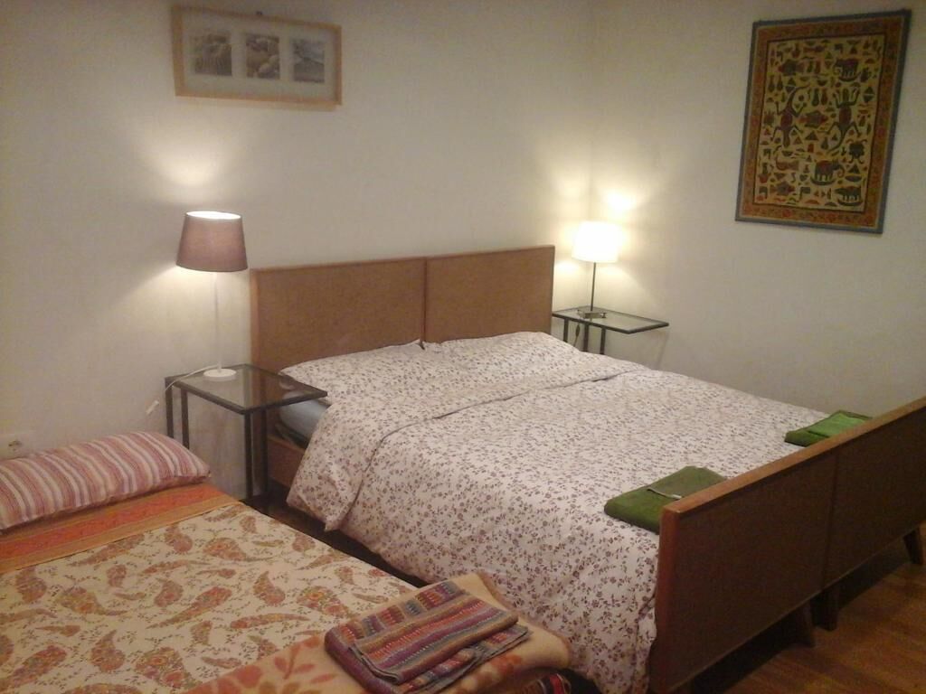Une chambre à coucher avec un lit double, des tables de chevet, une lampe et un tableau encadré au mur.