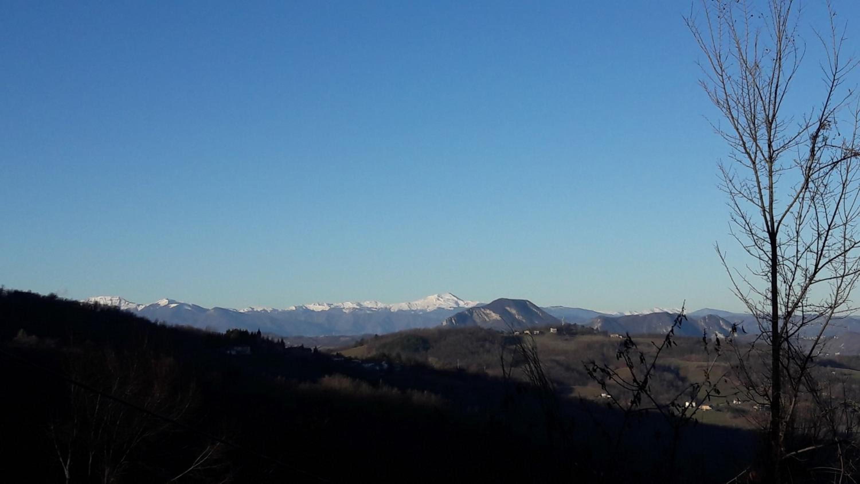 Un paisaje montañoso con picos nevados y cielo despejado.