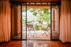 A sliding glass door leading to an outdoor patio with a table and two chairs. - Eclipse Bed and Breakfast (Cancun)