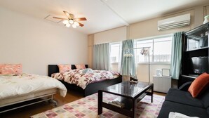 A hotel room with two beds, a sofa, a coffee table, a ceiling fan, an air conditioner, and a TV. - Private bedroom in a shared English-speaking house (大阪市)
