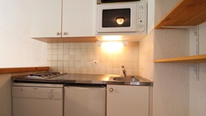 Une cuisine compacte équipée d’un four à micro-ondes, d’une cuisinière et d’un lave-vaisselle.