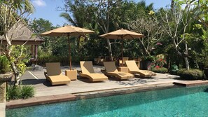 Een buitenzwembad, parasols voor strand/zwembad