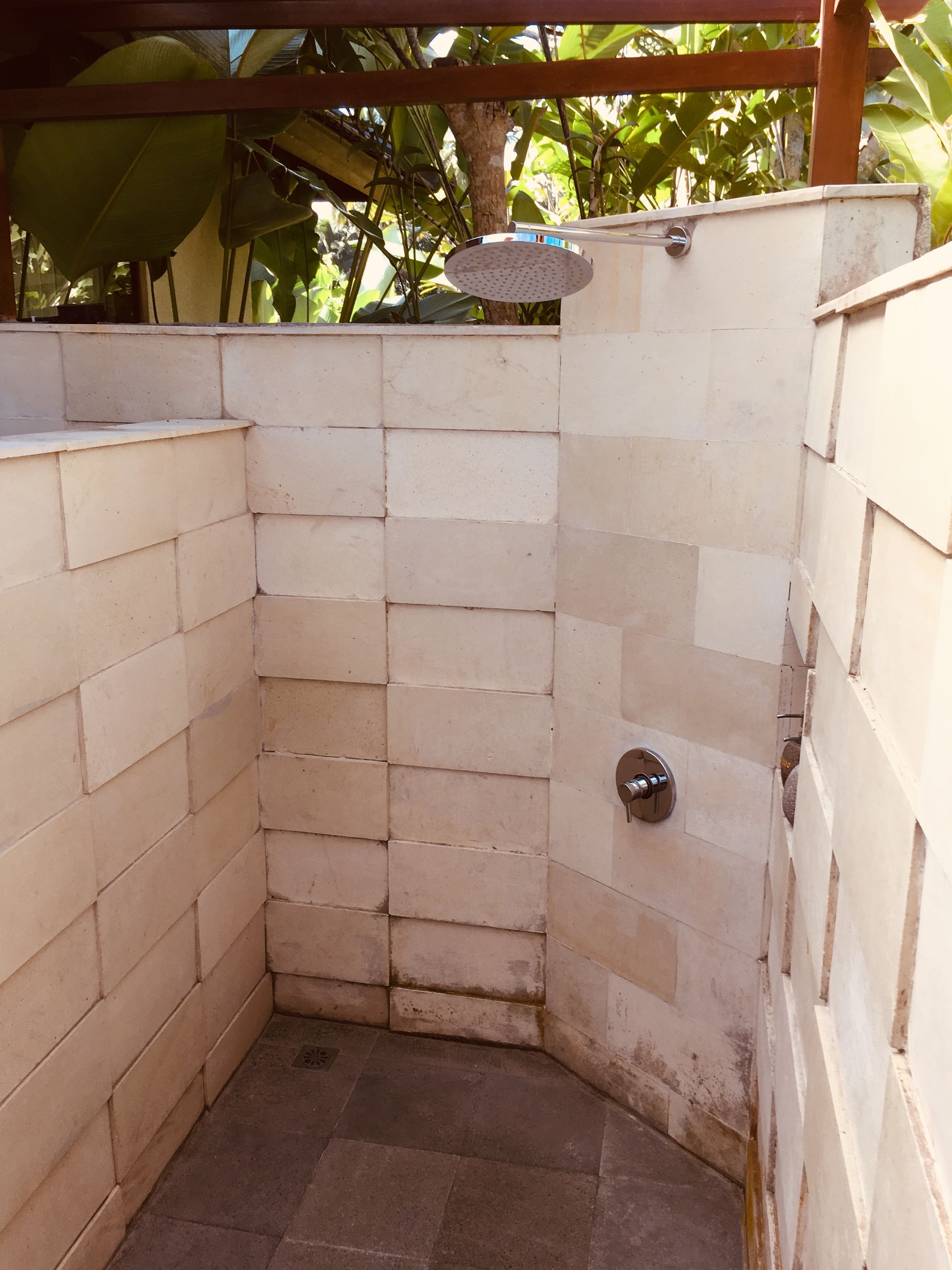 A small, enclosed shower area with tiled walls and a metal showerhead.