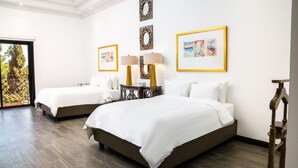 Una habitación de hotel con dos camas, una mesita de noche con lámparas y obras de arte en las paredes.