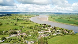 A river winding through a green landscape with a small village. - The Ship Inn (Gloucester)