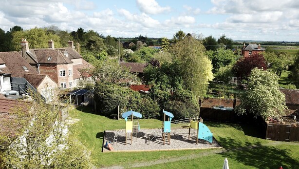 A residential area with a playground, a grassy lawn, and a row of lounge chairs. - The Ship Inn (Gloucester)