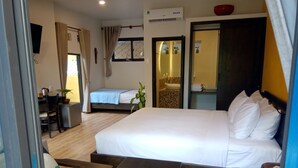 A hotel room with a large bed, a smaller bed, a desk with a chair, a dining table, and a bathroom with a sink and mirror. - MiNhon Hotel Mui Ne (Mui Ne)