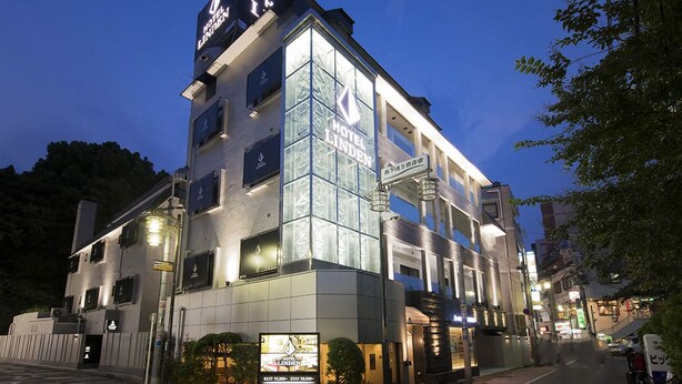 A multi-story hotel with a prominent glass facade and signage for Hotel Linden. - Hotel Linden Oji (Tokyo)