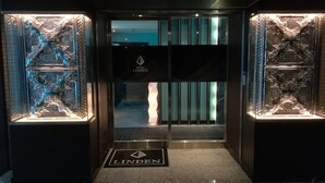 The entrance to Hotel Linden with ornate glass panels and a sign indicating the hotel's name. - Hotel Linden Oji (Tokyo)